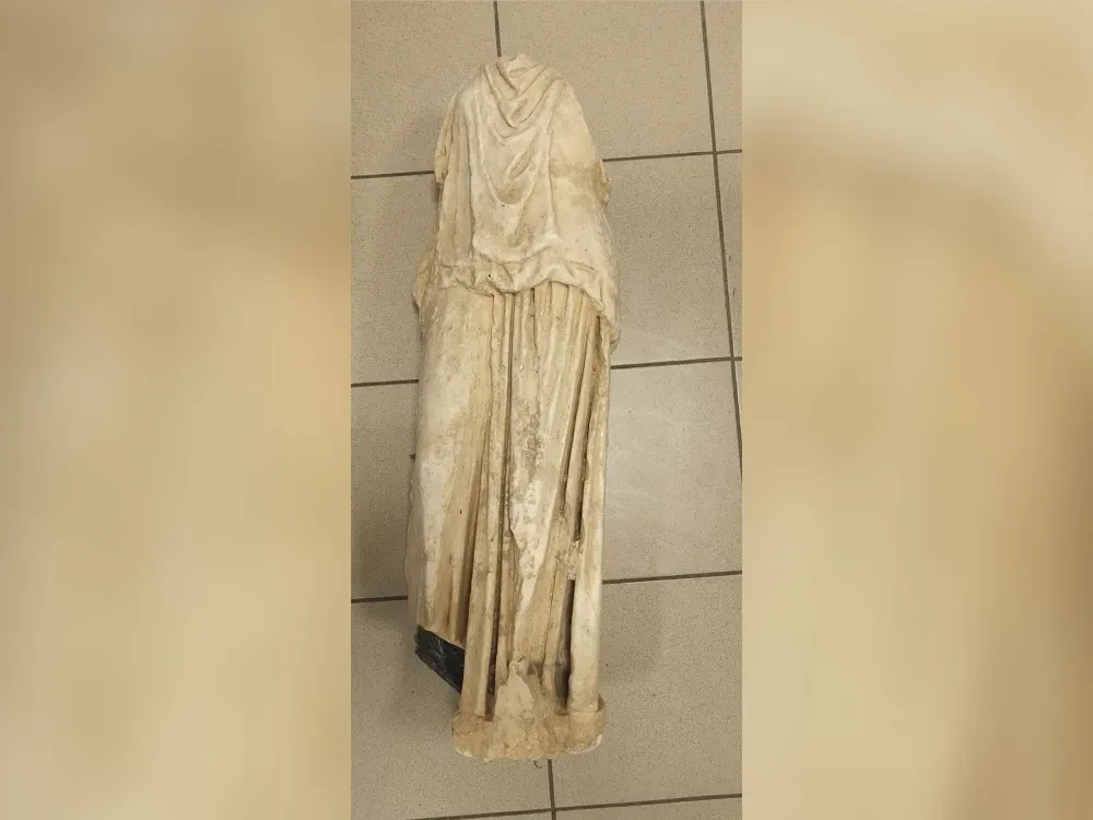 A recently discovered ancient statue, missing its arms and head, is displayed for investigation by Greek authorities.