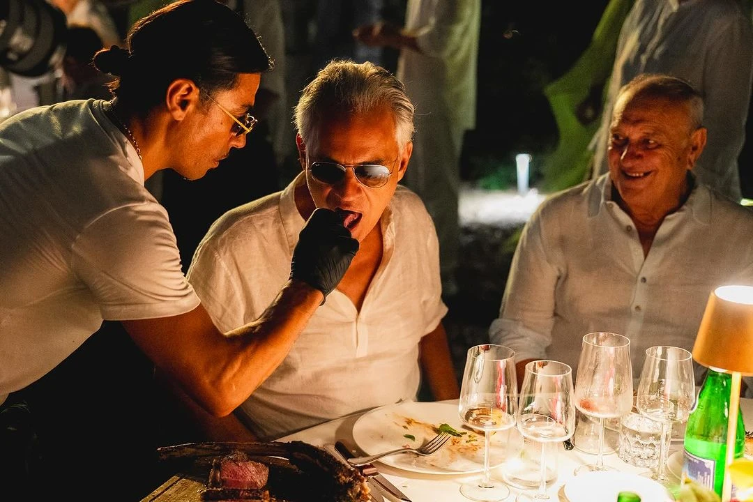 'Salt Bae' chef Nusret Gokce serves a piece of steak to renowned tenor Andrea Bocelli during the intimate dinner at Villa Alpebella, Forte dei Marmi, Italy.