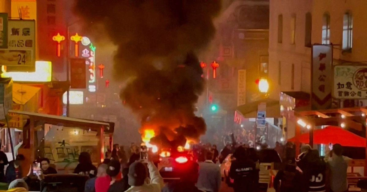 Waymo self-driving car is ignited by crowd in San Francisco.