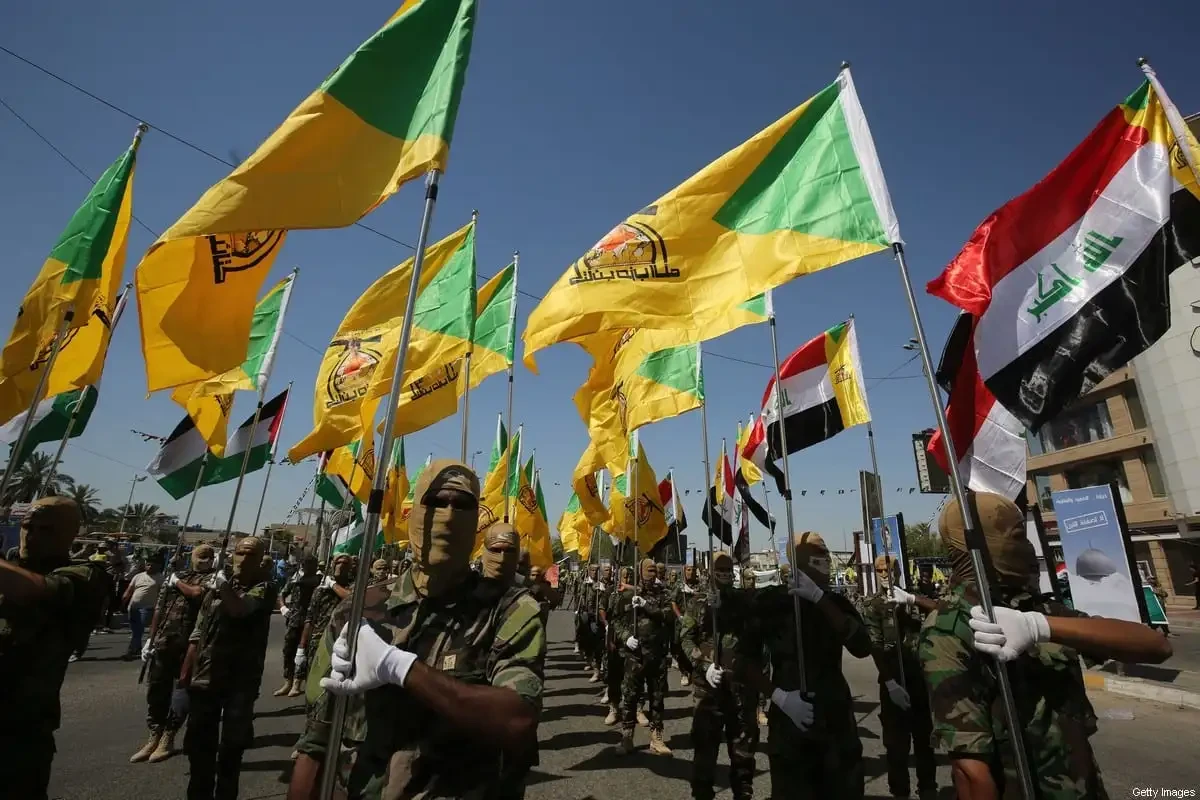 Photo shows Hezbollah brigades march in Baghdad carrying flags of the group and Iraq