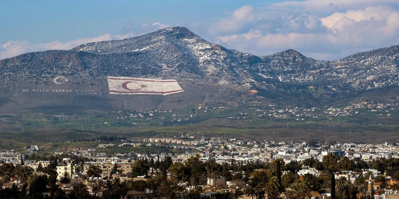 A view of snow covering a portion of Cyprus' northern Girne mountain range, above the flag of the Turkish Cyprus