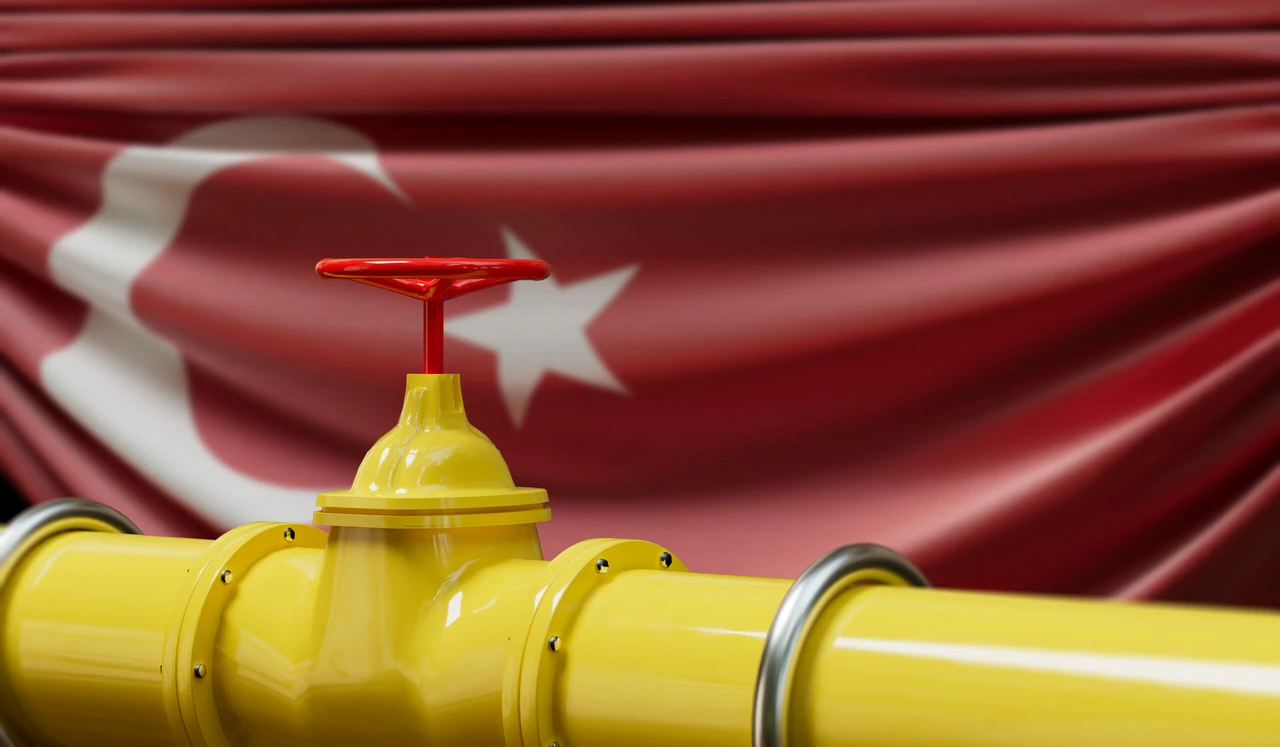 Photo shows a gas pipeline with a red valve on it, Turkish flag waving behind