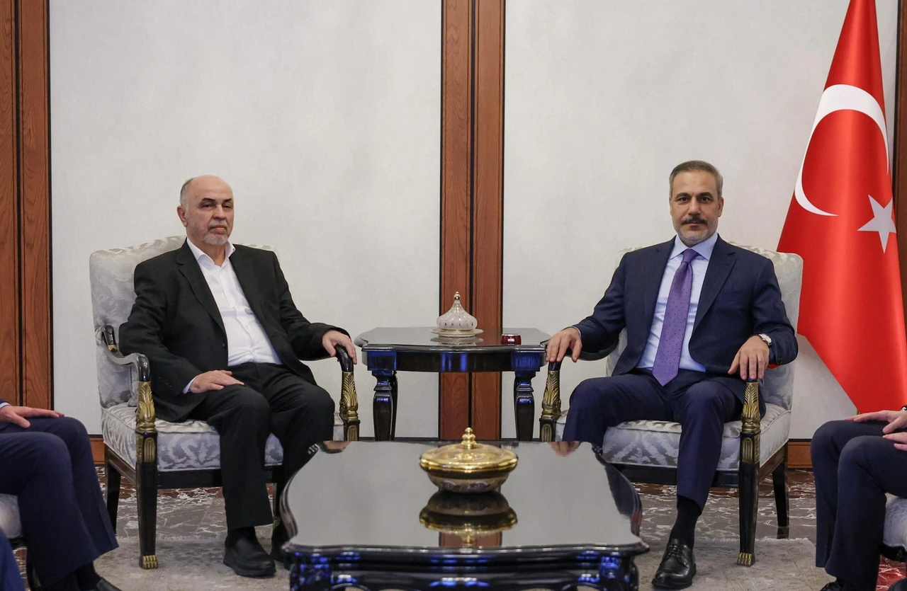 Photo shows Turkish Foreign Minister Hakan Fidan (R) and the Hamas Shura Council Chairman Muhammad Darwish (L)