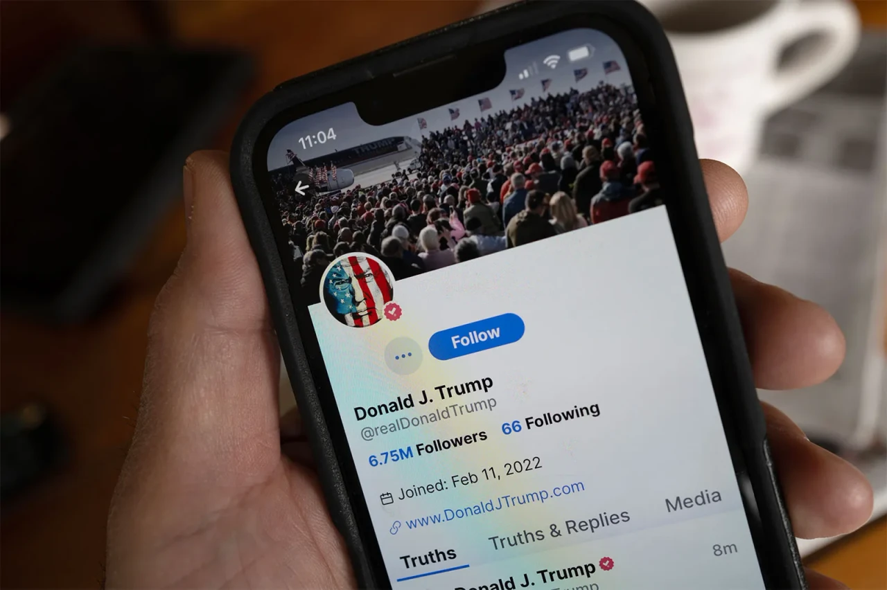 Photo shows Donald J. Trump's Truth Social profile shown on a phone screen held on hand