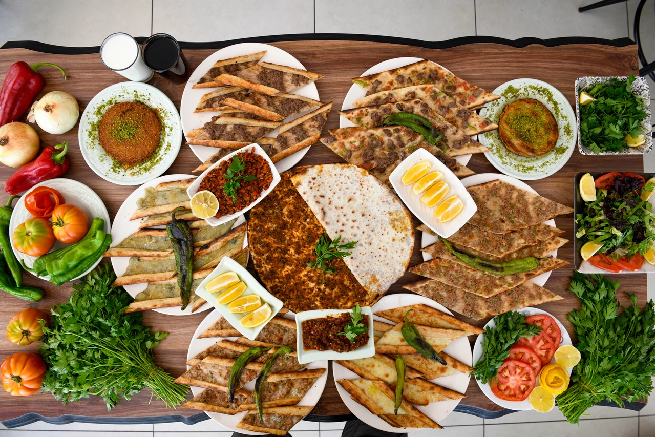 A spread of popular Turkish dishes like lahmacun and pide, as recent discussions raise concerns over mechanically separated meat in Türkiye’s food industry. (Adobe Stock Photo)