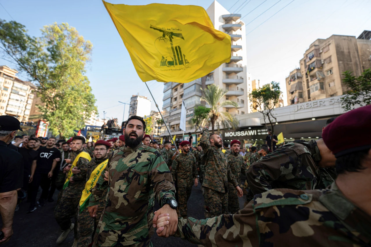 Hezbollah operatives form a human barrier during the funeral procession of top Hezbollah commander Fuad Shukr