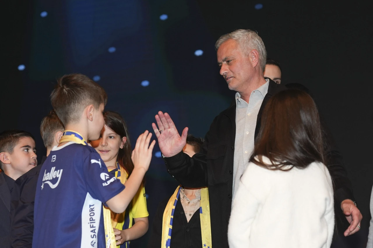 Jose Mourinho, Fenerbahçe's head coach, holds the "Project of the Year" award at the 2024 Aydınlık Gelecek Awards ceremony, surrounded by children and members of 1907 ÜNİFEB.