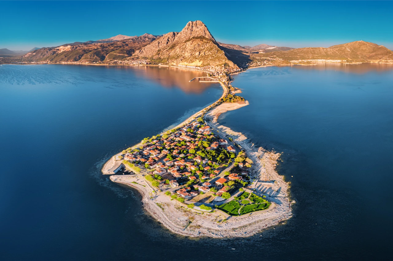 A breathtaking aerial view of Eğirdir Lake at sunset in Isparta, Türkiye, with the sky painted in warm tones reflecting on the tranquil waters.