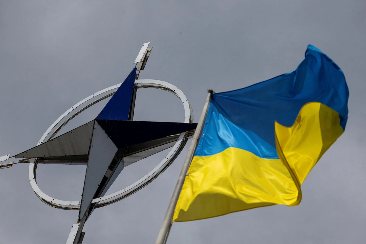 A Ukrainian national flag is pictured in front of the NATO emblem