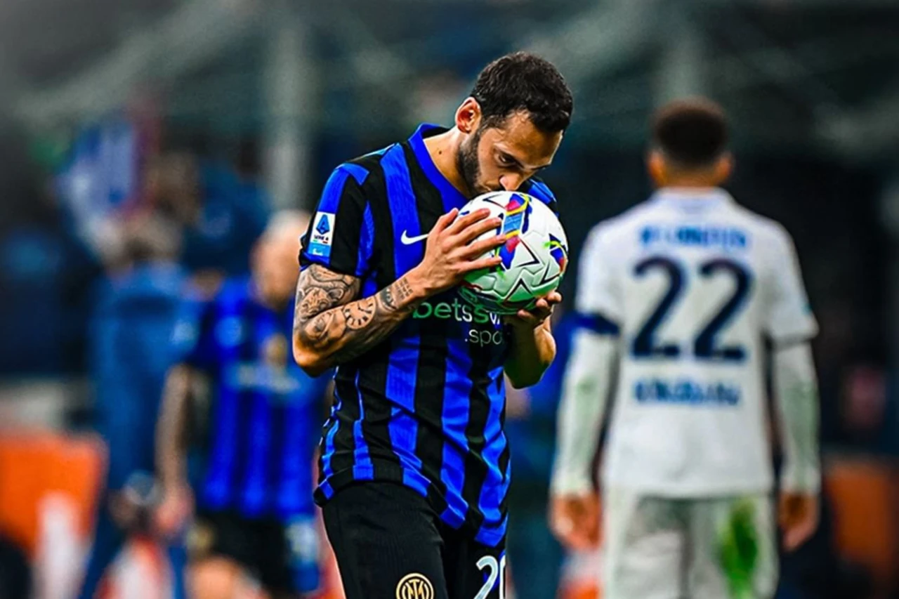 Hakan Calhanoglu kisses the ball, showing his dedication to his team during a match in Milan