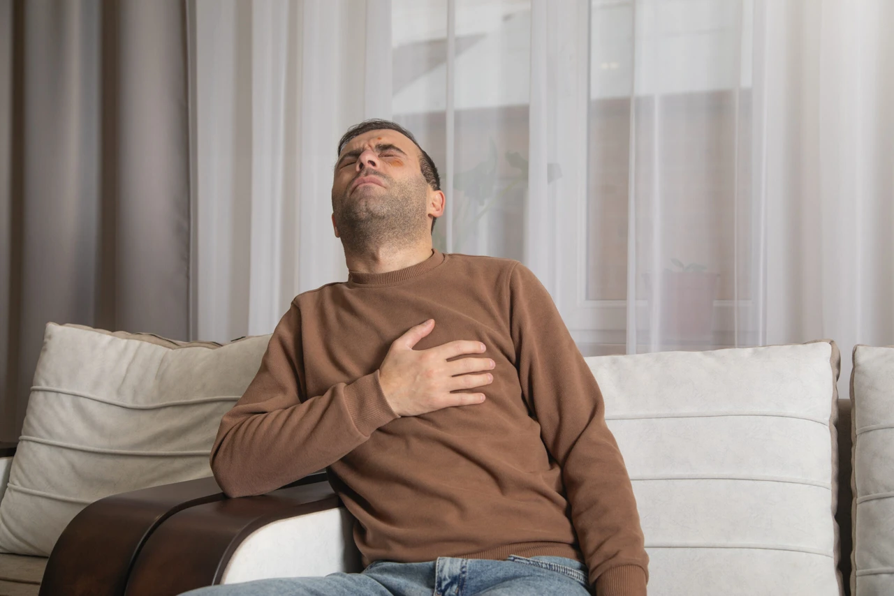 A man experiencing a heart attack at home, clutching his chest in pain.