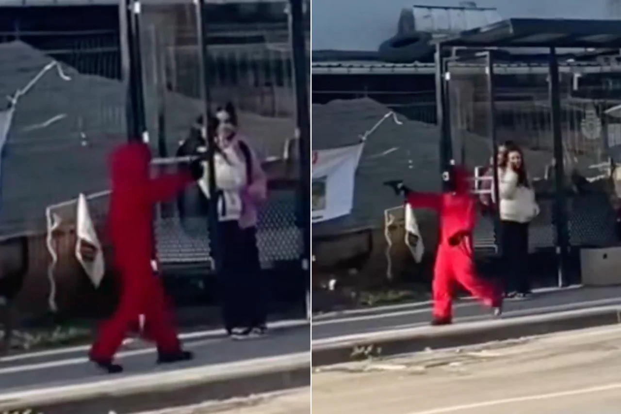 A child in Türkiye, dressed in a red Squid Game costume and holding a toy weapon, causes alarm at a bus stop in Istanbul as bystanders react