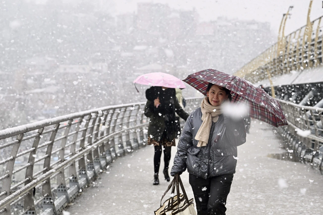 People walking in Istanbul, Türkiye, during a snowfall on February 19, 2025.