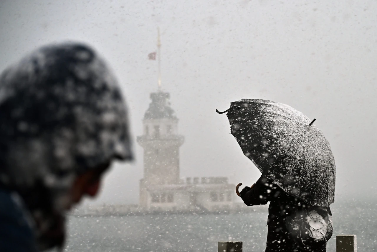 A man shields himself from the snow with an umbrella as the snowfall continues in Uskudar, Istanbul.