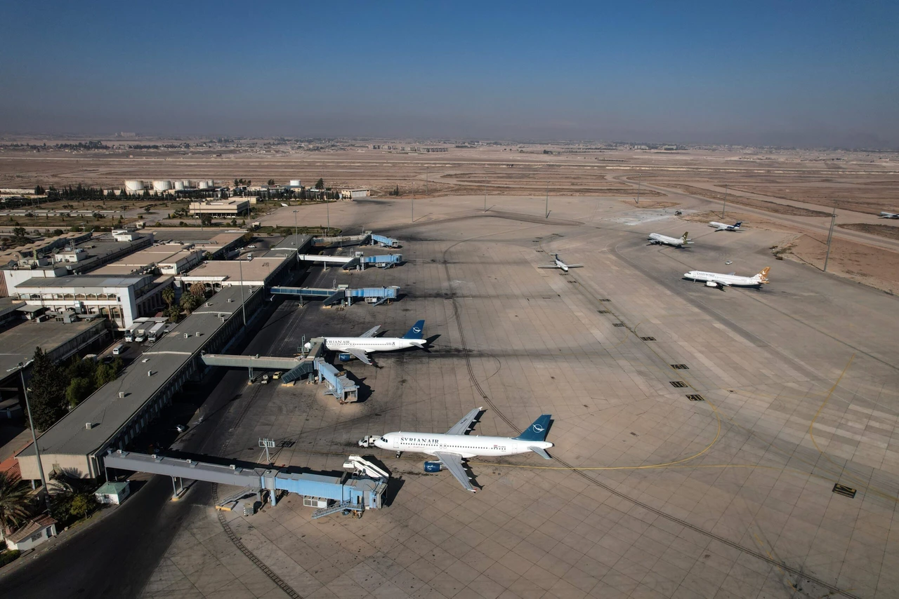 Aerial view of Damascus International Airport, showing multiple airplanes parked near passenger boarding bridges