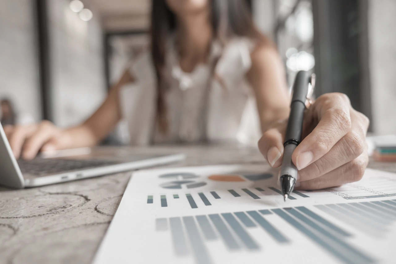 Businesswomen analyzing investment graph and discussing plan in meeting room, investment concept