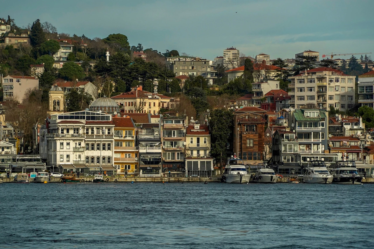 rental prices A scenic view of Bebek district in Istanbul, captured from a Bosphorus cruise, showcasing the waterfront, lush greenery, and elegant architecture.