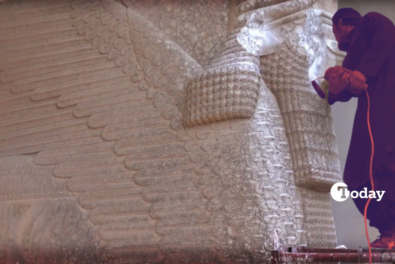 A Daesh militant is using a power tool to damage an Assyrian winged bull sculpture at the Mosul Museum in Iraq.