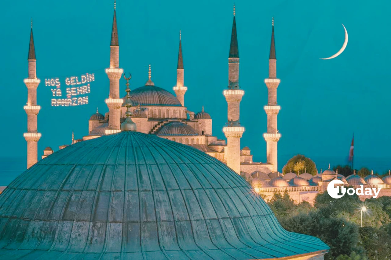 The Blue Mosque in Istanbul at dusk with Ramadan 2025 lights displaying 'Hoş Geldin Ya Şehr-i Ramazan' (Welcome, O City of Ramadan) against a crescent moon.