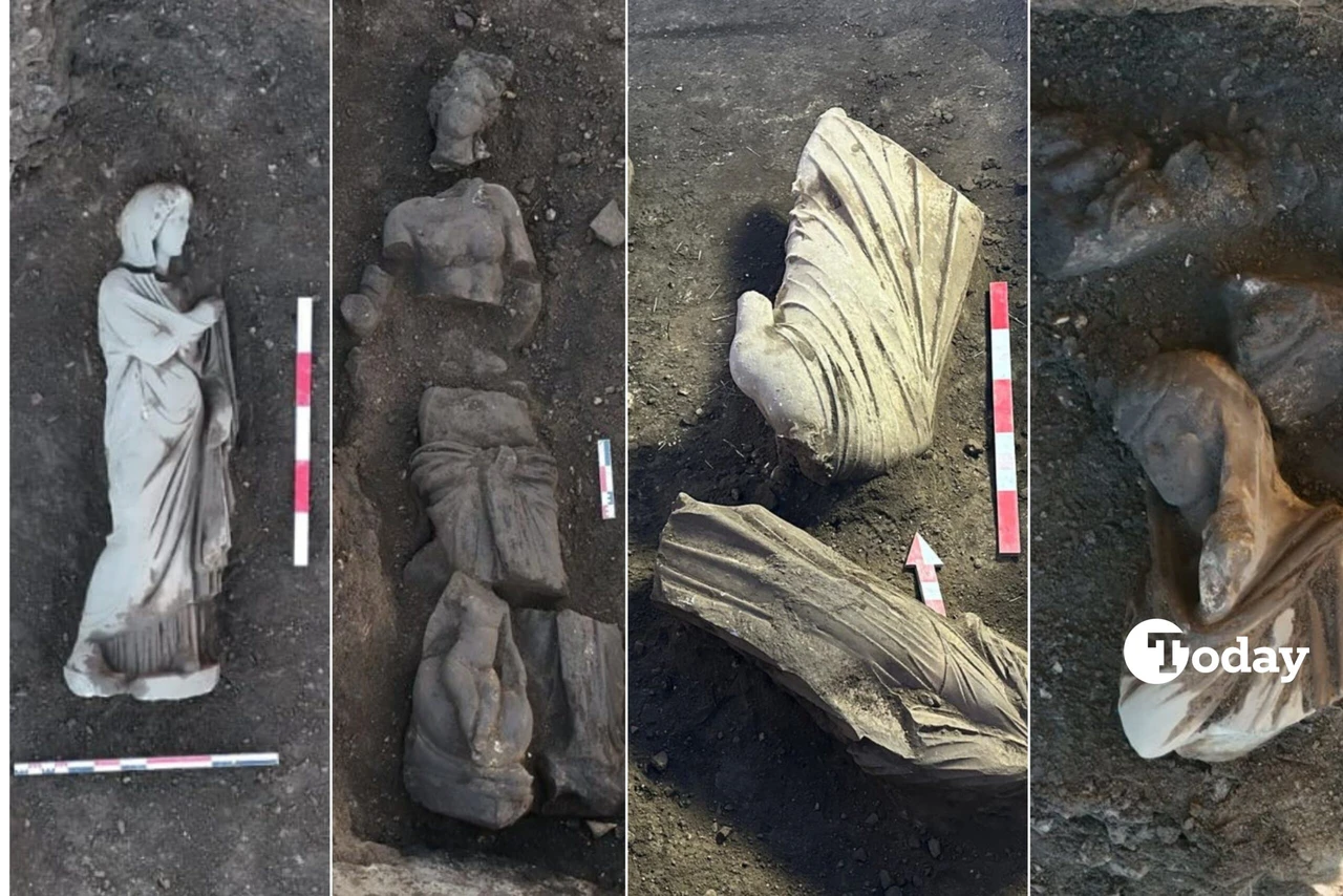 Five ancient statues of varying styles and sizes, unearthed at the archaeological site of Perge in Türkiye, displayed in an excavation area with visible ruins in the background.