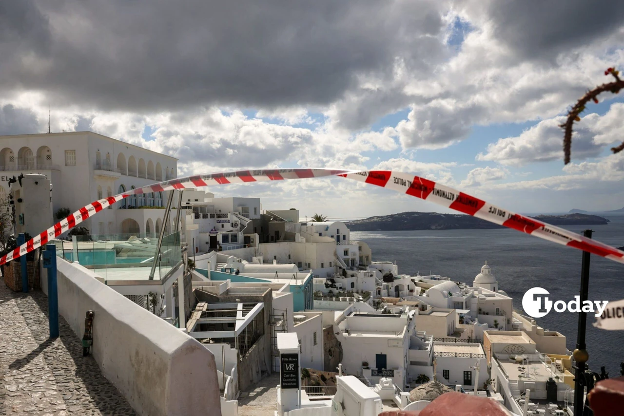 A closed stone-paved path in Fira, Santorini, with warning signs and barriers, as seismic activity increases on the island.