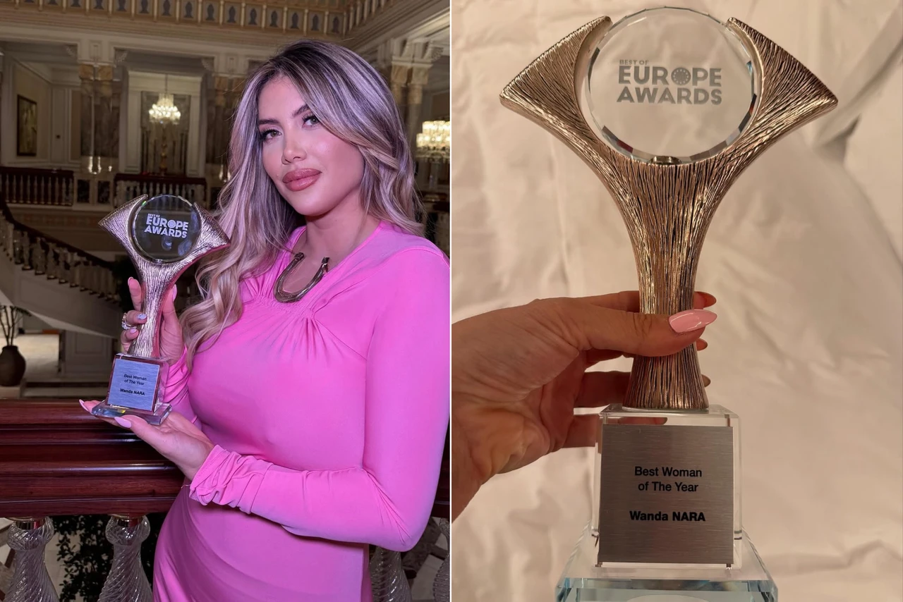 Wanda Nara in a pink dress holding her ‘Woman of the Year’ award at the Best of Europe Awards, with a grand staircase behind her.