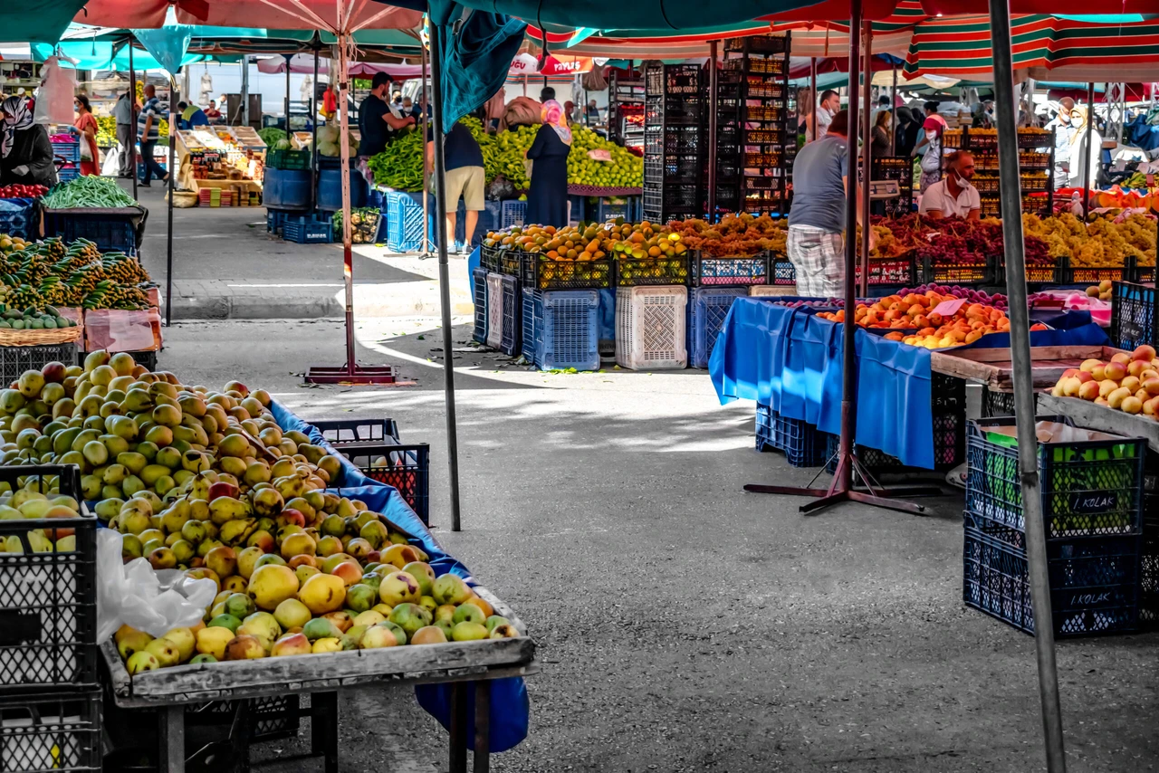 Alanya, Turkey - October 23, 2020: Vegetable and fruit stalls in Alanya street food market. Tables with heaps of farm products under umbrellas, outdoors