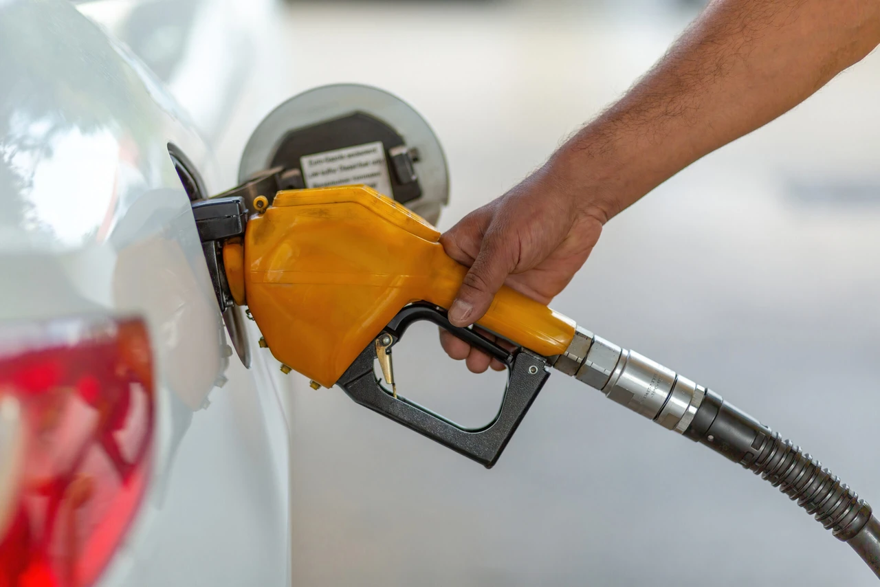 Yellow fuel nozzle pumping gas into white car