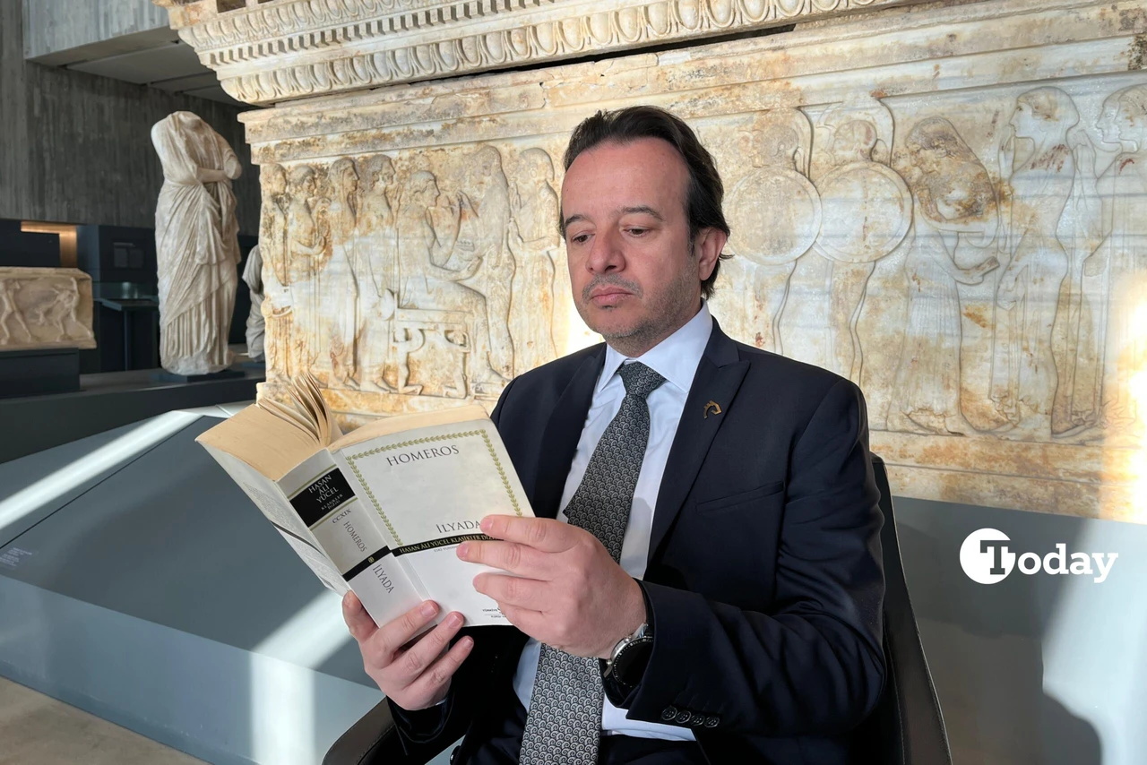 Troy Museum Director Ridvan Golcuk reading Homer's Iliad in front of the Polyxena Sarcophagus.