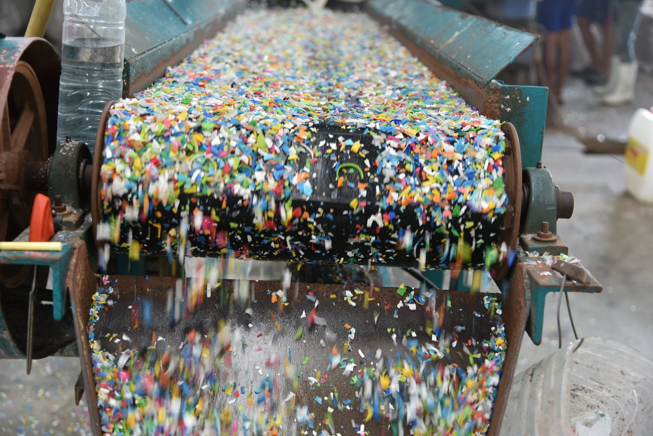 Plastic bottles stacked and placed on a conveyor belt for recycling.