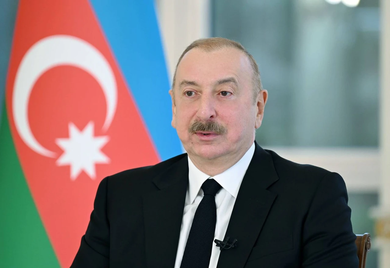 Azerbaijan's President Aliyev discusses Palestine, Syria and regional security 2 Photo shows Azerbaijani President Ilham Aliyev in front of flag of Azerbaijan