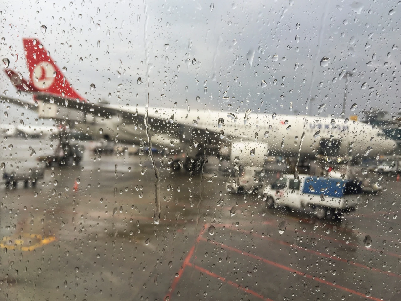 an airport window covered with raindrops