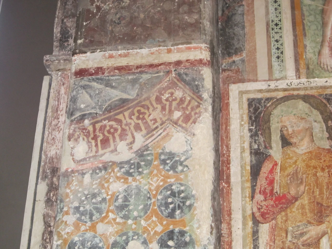 13th-century fresco showing tent-like textiles with eight-pointed star motifs and pseudo-Arabic inscriptions. A 15th-century fresco section is visible on the right.