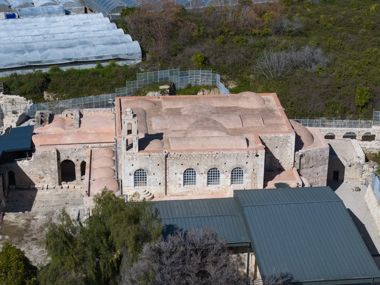 Aerial drone view of St. Nicholas Church in Demre, Antalya, Türkiye, showcasing its historic architecture and surrounding landscape.