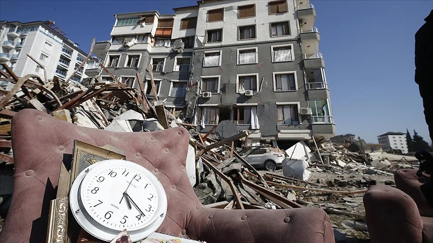 A clock showing 4:17 a.m. sits on the rubble of a collapsed building, symbolizing the exact moment the earthquake devastated southern Türkiye