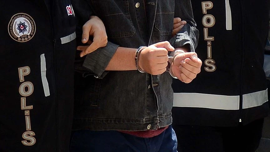 A person in handcuffs being escorted by two police officers