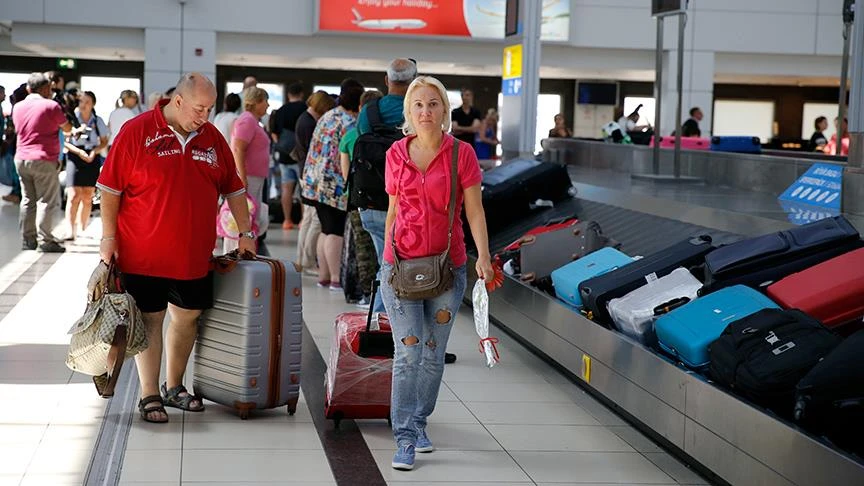 Foreign tourists collect their luggage at a baggage claim area