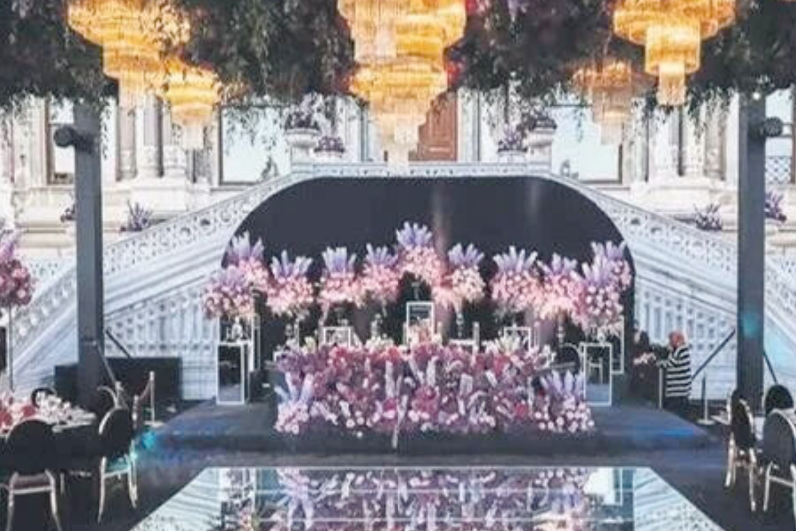 Ornate wedding stage adorned with purple and pink floral arrangements, chandeliers, and elegant decor in Istanbul, Türkiye. wedding on Bosphorus