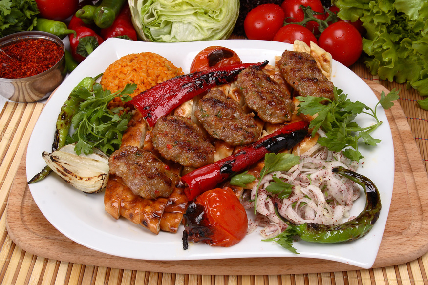 Turkish meatballs served with grilled vegetables, flatbread, and bulgur—a classic dish with countless regional variations