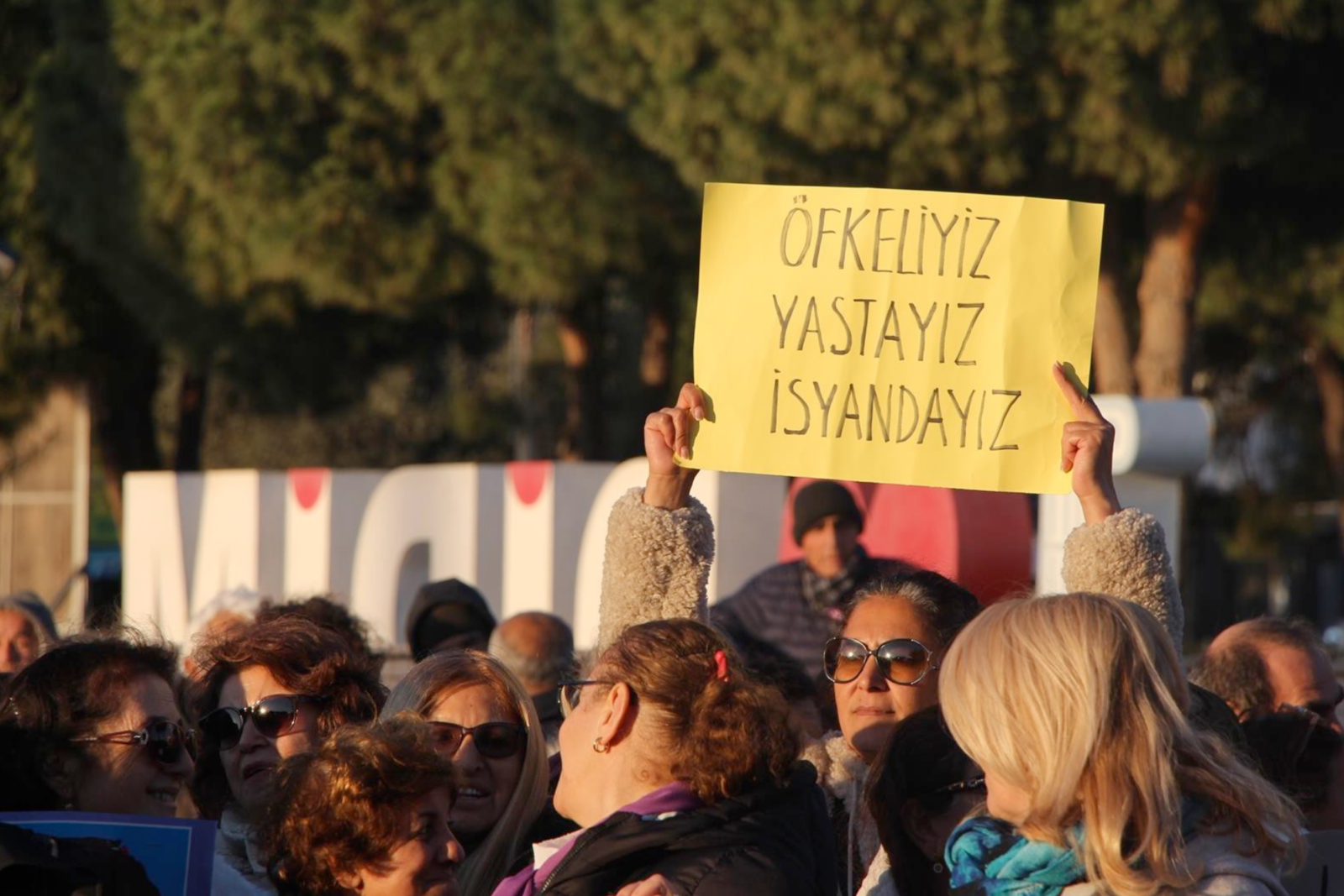 An woman holds a sign that reads, "We are angry, we are in mourning, we are in revolt," during a demonstration in Türkiye