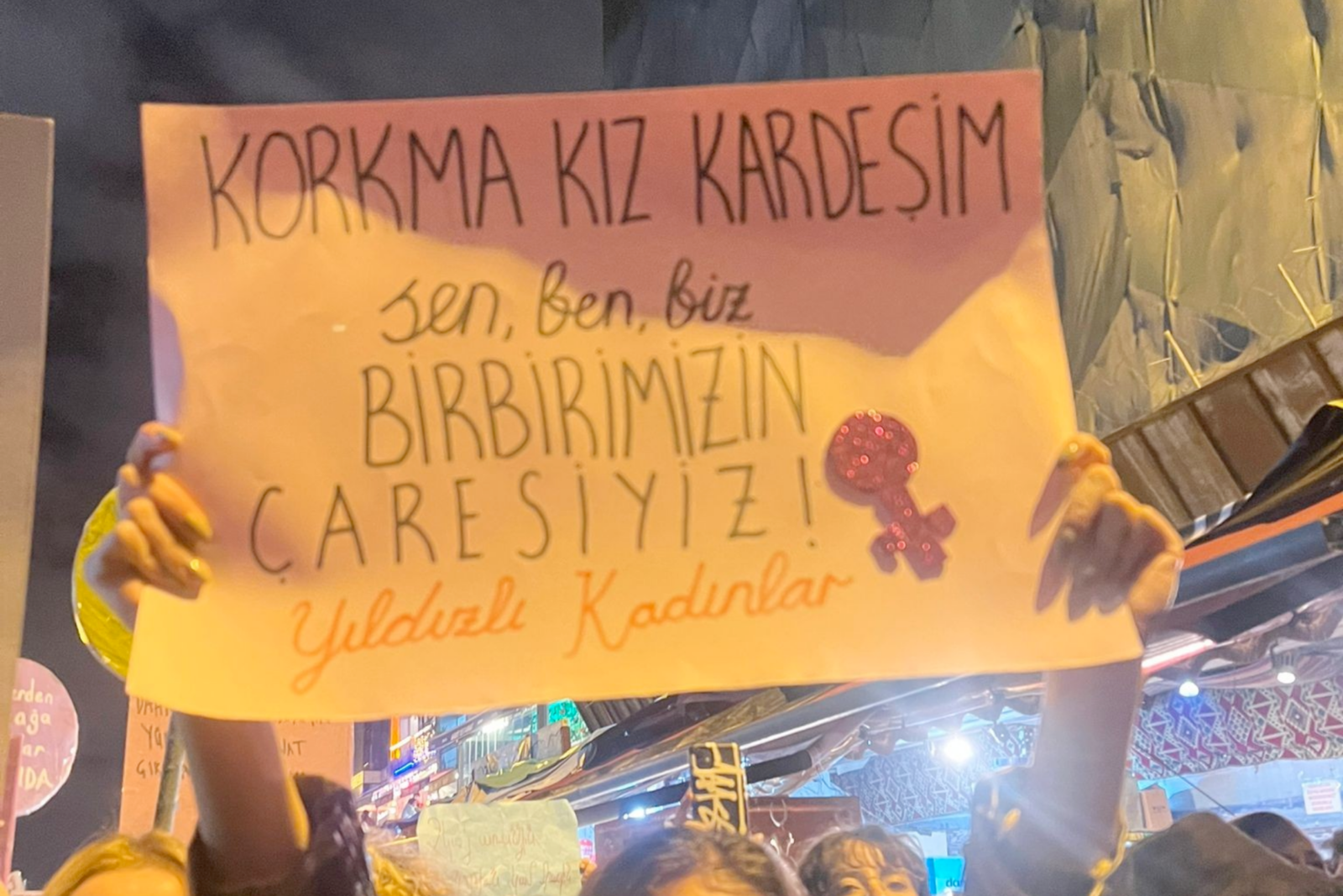 A sign held by protesters reads, "Don’t be afraid, sister. You, me, we are each other’s remedy," in Istanbul, Türkiye