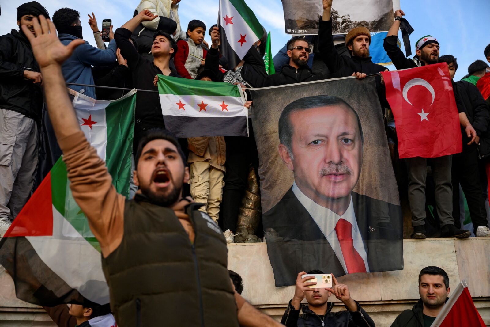 People seen holding a banner featuring President Recep Tayyip Erdogan.