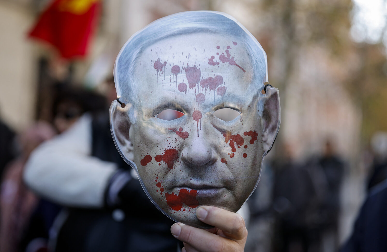 A demonstrator holds a blood-stained mask depicting Israeli Prime Minister Benjamin Netanyahu