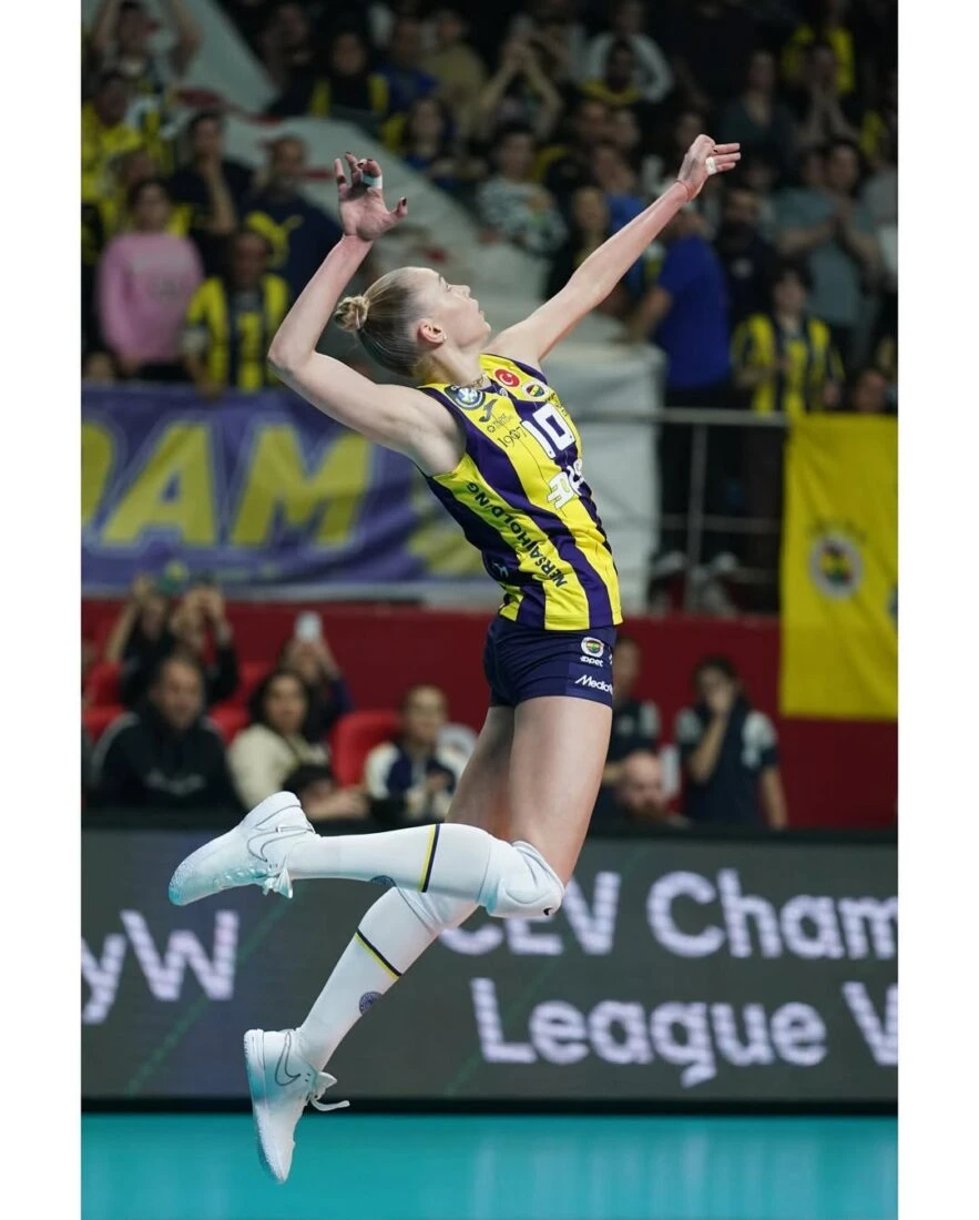 Arina Fedorovtseva leaps for a spike during a high-energy volleyball match in Fenerbahce colors