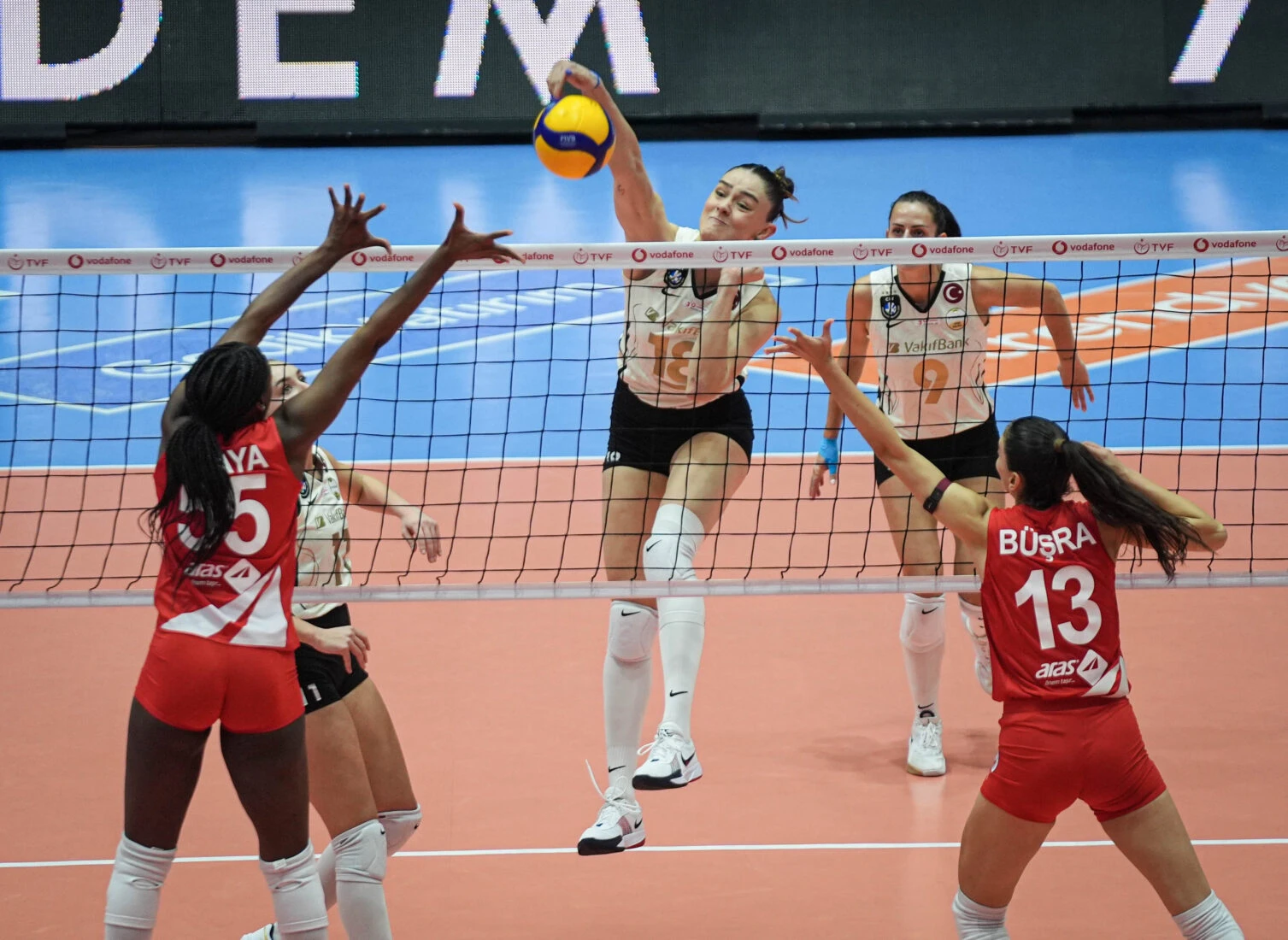 Karina Olaya (55) and Busra Gunes (13) compete at the net with VakifBank's Zehra Gunes