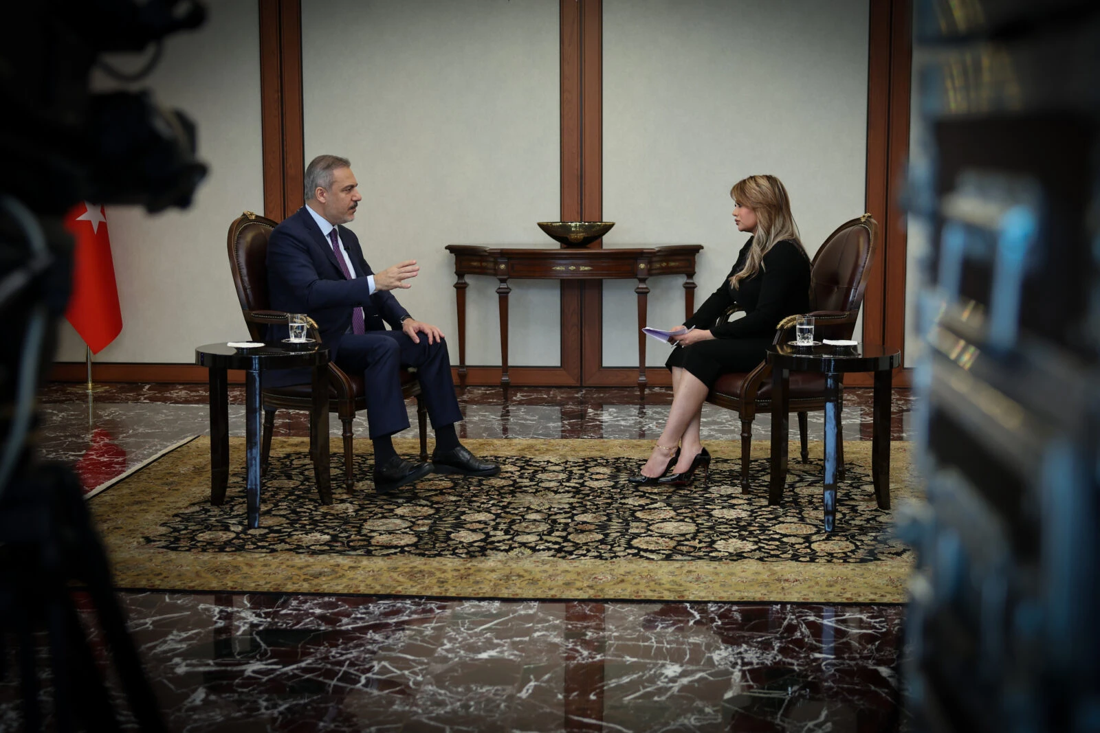 Turkish Foreign Minister Hakan Fidan speaks to a journalist talking