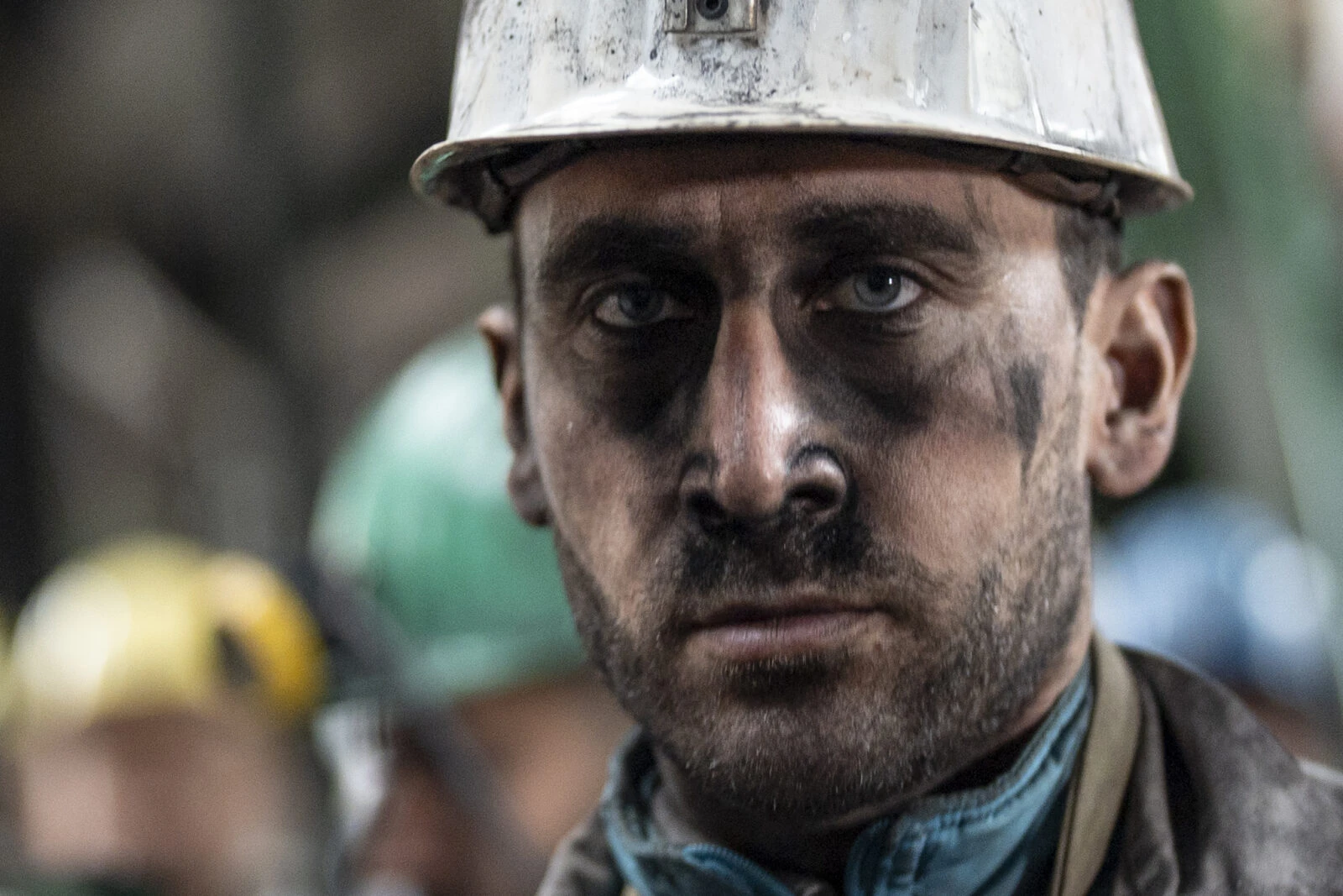 A coal miner with a soot-streaked face looks exhausted as he poses at a mine site in Zonguldak, Türkiye, during World Miners' Day.