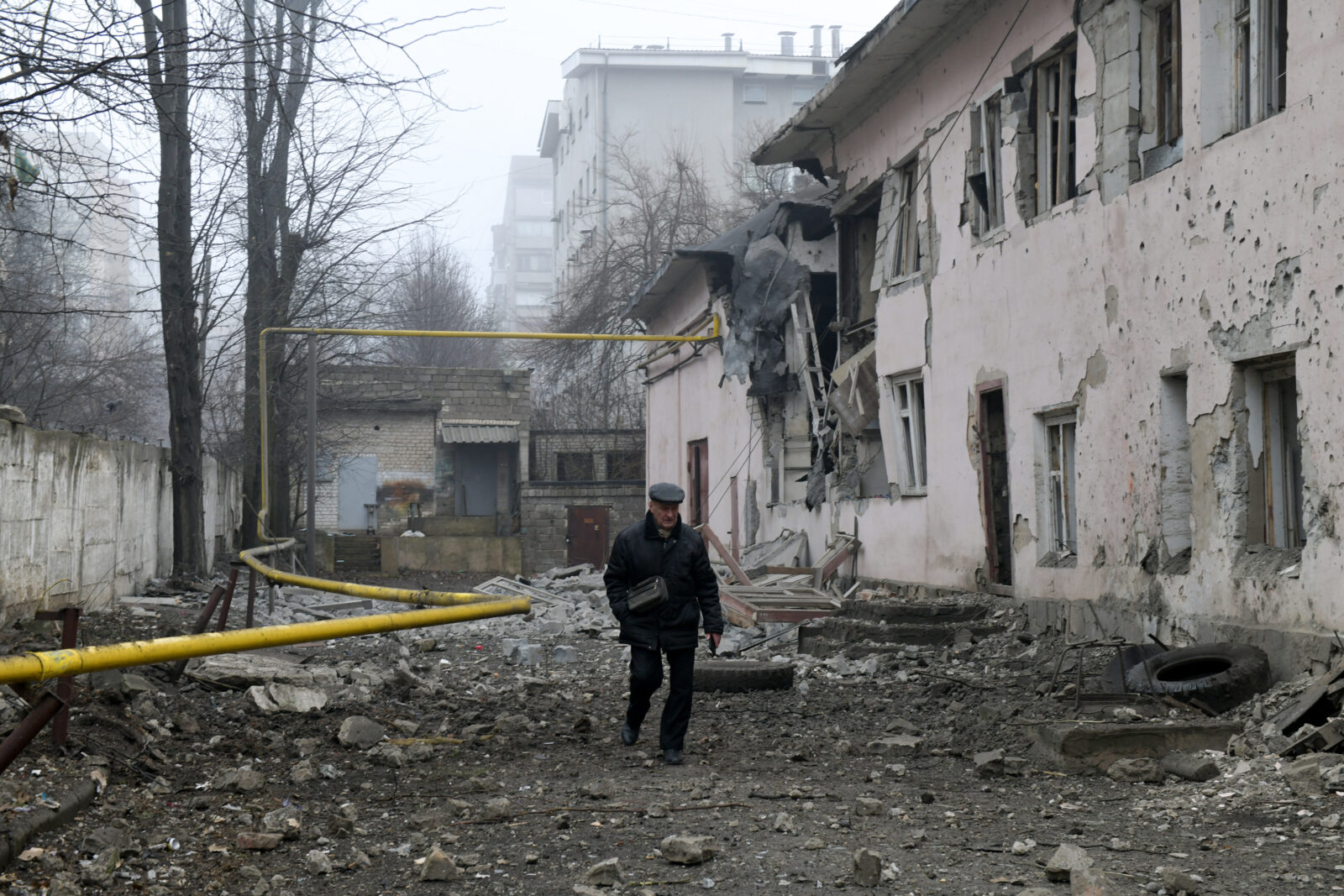 A man walks at the site of shelling