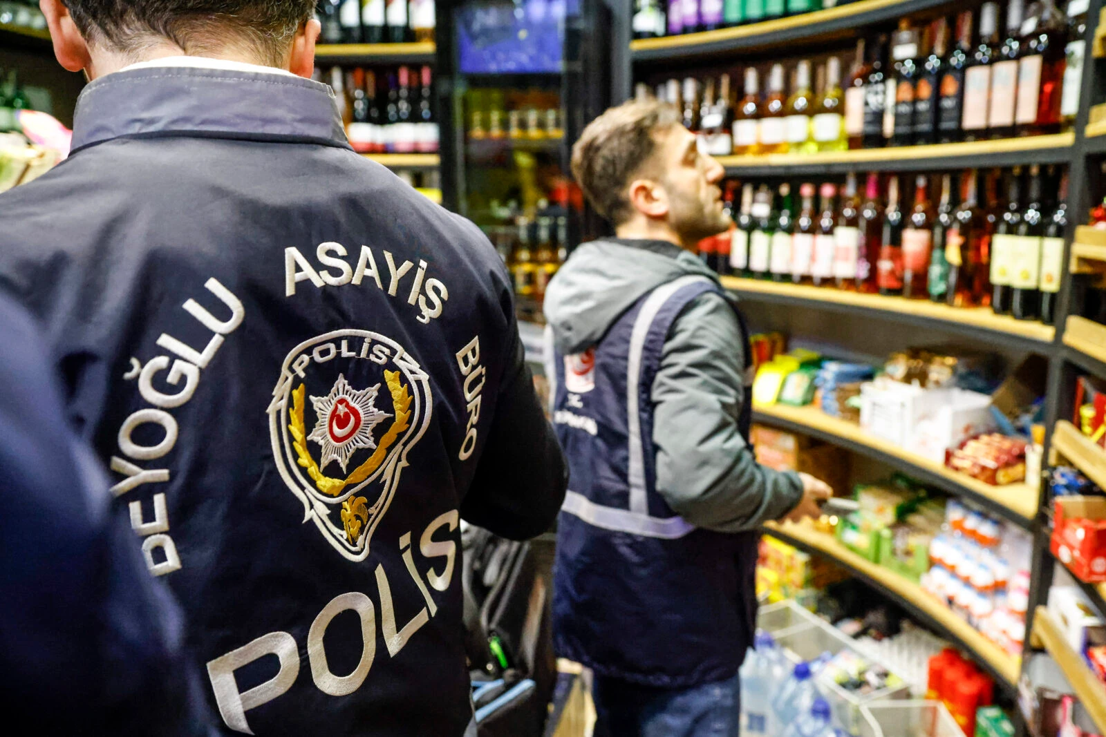 A Turkish police officer inspect bottles in a liquor shop