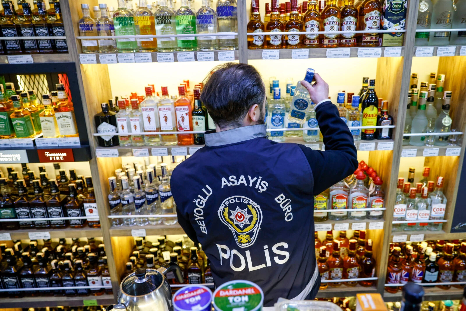 A Turkish police officer inspect bottles in a liquor shop 